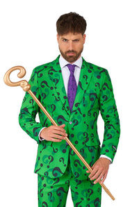 A man with a serious expression models The Riddler costume by Suitmeister, featuring a green suit adorned with black question marks, a purple tie, and a gold cane topped with a question mark, all set against a white background.