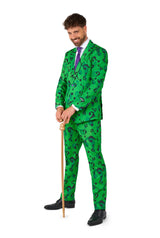 A man dressed in Suitmeister's The Riddler suit, featuring a green ensemble adorned with black question marks, a white shirt, and a purple tie, while holding a gold cane. He is smiling confidently against a white background.