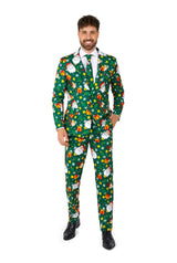 A man in the Santa Elves Green - Christmas suit by Suitmeister, adorned with cheerful patterns of Santa faces, presents, and stars, stands smiling. The suit features a predominantly green color with red, white, and yellow highlights.