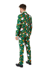 A man stands with his back turned, dressed in the Santa Elves Green - Christmas suit by Suitmeister. The suit features festive holiday patterns such as Santa Claus, presents, and stars. He has brown hair and is wearing black shoes against a white background.