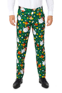 A person is dressed in the Suitmeister's "Santa Elves Green - Christmas suit," showcasing a festive print with Santa, snowflakes, and presents. They have paired it with a white shirt and black shoes.