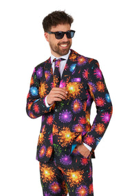 A man dressed in the Suitmeister Fireworks Black NYE suit, smiling and adjusting his tie while wearing sunglasses against a plain white background.