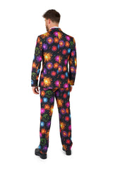 A person is seen from behind, donning the Suitmeister "Fireworks Black" suit, which showcases a striking fireworks pattern in vivid colors such as red, orange, yellow, purple, and blue to create a festive and bold appearance.