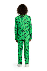 A person with curly hair stands facing away from the camera, dressed in The Riddler suit from Suitmeister, featuring a vibrant green color adorned with black question mark patterns. They complete the look with a pair of white shoes, all set against a simple white background.