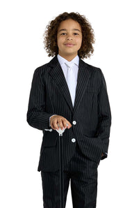 A young child with curly hair is confidently standing against a white background, dressed in the Gangster Pinstripe Black suit by Suitmeister. They are wearing a white shirt and holding a black cane.