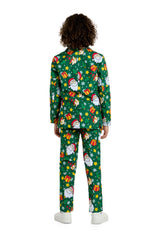 A person with curly hair is facing away, dressed in the Santa Elves Green - Christmas suit by Suitmeister, showcasing a vibrant pattern of Santa Claus, gifts, and snowflakes. They complete the festive look with white shoes.