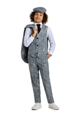 A young boy confidently poses in the "20's Gangster Grey" outfit by Suitmeister, featuring a grey vest and pants with a matching cap. He casually drapes a grey jacket over his shoulder, completing his look with a white shirt, black tie, and white sneakers against a plain white background.