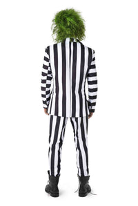 A person dressed in a Suitmeister Beetlejuice costume, featuring wild green hair, a black and white striped suit, and black boots, facing away.