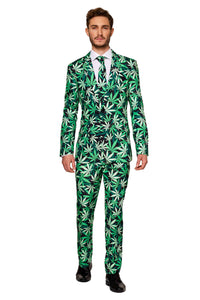 A man confidently stands, dressed in the Cannabis suit by Suitmeister, which features a striking green cannabis leaf pattern. The ensemble includes a matching tie over a crisp white shirt, complemented by black shoes.