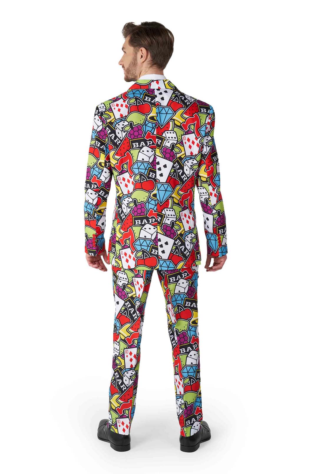 A person wearing the Suitmeister "Casino Icons" suit, featuring a vibrant casino-themed pattern with dice, playing cards, diamonds, and slot machine graphics. The individual is standing with their back to the camera.