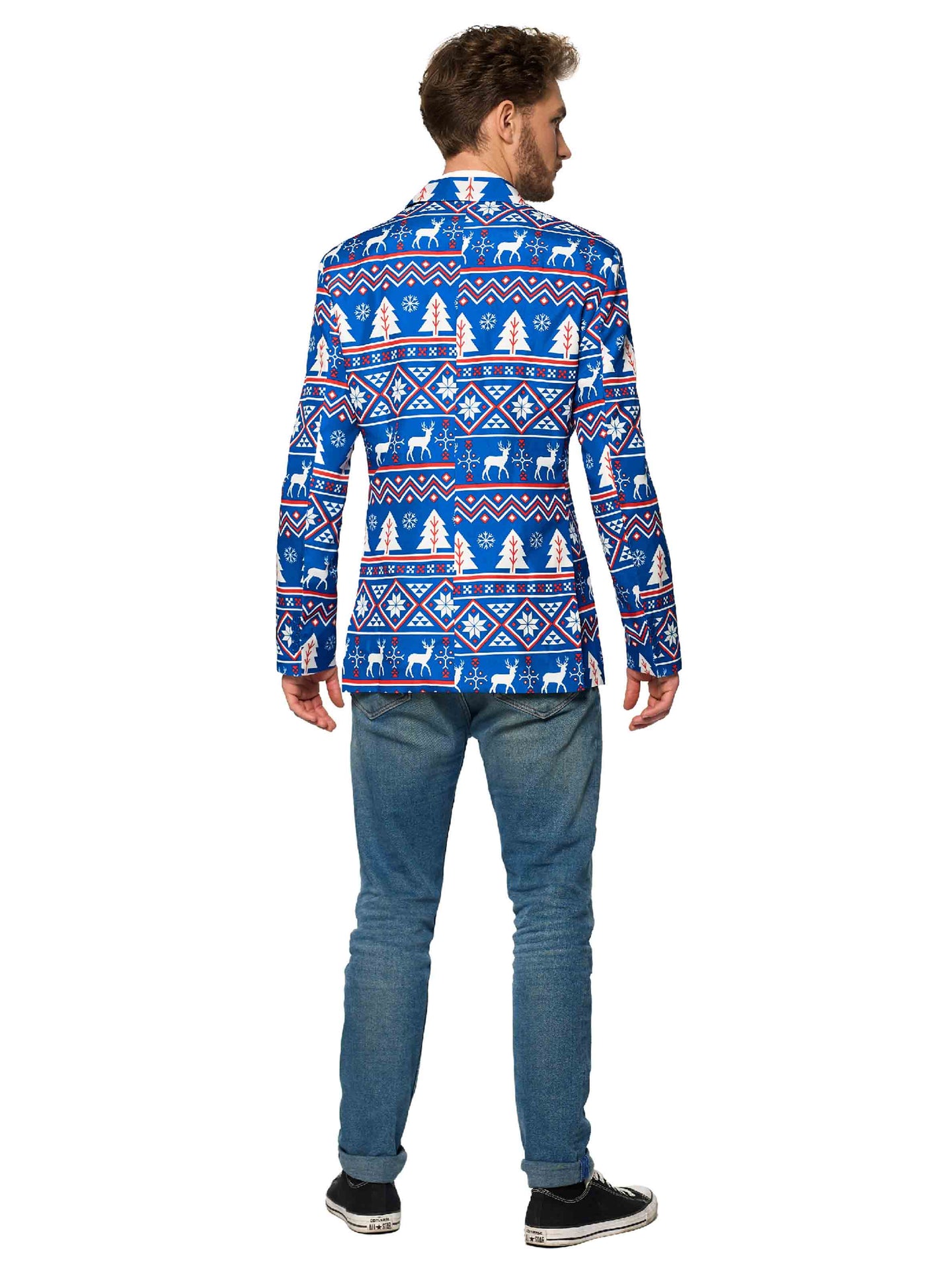 A man stands with his back to the camera, donning a Christmas Blue Nordic Jacket from Suitmeister, featuring white and red holiday patterns such as snowflakes and reindeer. He pairs it with blue jeans and black sneakers against a plain white background.