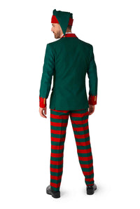 A man dressed as an elf is seen from the back, wearing the Suitmeister Santa's Elf Green - Christmas Elf Suit, which includes a green jacket with red accents, red and green striped pants, and a pointed hat.