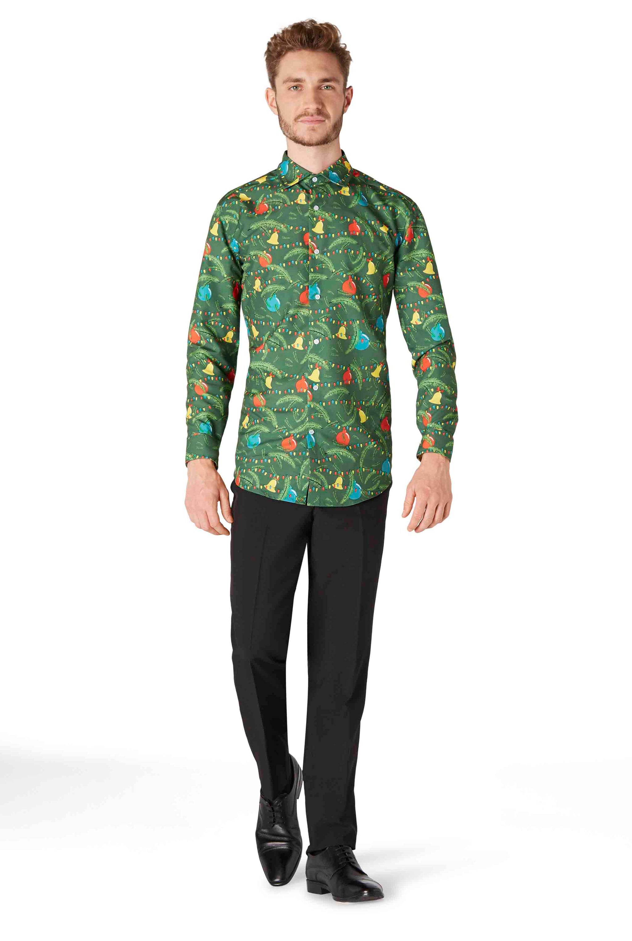 A man wearing a Christmas Green Tree Shirt from Suitmeister, featuring a jungle-themed design with colorful animals and foliage, paired with black pants and shoes, standing against a white background.