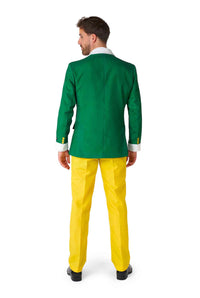 A man stands with his back to the camera, dressed in the vibrant green "Elf™ - Christmas Suit Elf" by Suitmeister. Complementing his attire are yellow pants and black shoes. His hair is short, and he appears to be glancing slightly to his left against a plain white background.