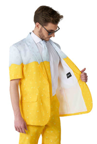 A man wearing a short-sleeved suit in the vibrant colors and speckled pattern of the Suitmeister Premium Beer Yellow design checks the lining. He pairs it with glasses and a white shirt. The suit's striking appearance brings to mind the design of a fizzy drink can.