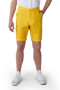 A person is wearing a white shirt, white sneakers, and bright yellow shorts with an abstract pattern from Suitmeister's Premium Beer Yellow line. The shorts feature convenient pockets, and the entire scene is set against a plain white background.