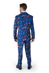 A man wearing the Retro Gamer Navy suit by Suitmeister stands with his back to the camera. The suit showcases a playful outer space pattern featuring rockets, planets, and stars. He pairs it with black shoes against a plain white background.