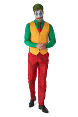 Styled in the Scarlet Joker™ outfit by Suitmeister, an individual is dressed as a clown character in a green shirt, yellow vest, red tie, and patterned red pants. They sport green hair and face paint featuring blue designs with red lips while moving forward.