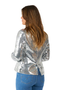 Standing against a white background, a person with long brown hair faces away while wearing the Sequins Silver sequin blazer by Suitmeister and blue jeans.