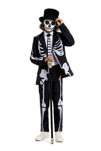 The individual is dressed in the Skeleton Grunge Black suit by Suitmeister, featuring a skeleton-themed design. Their face is painted to resemble a skull, and they accessorize with a black top hat and a cane topped with a skull, all set against a white background.