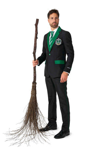 A man dressed in a Suitmeister Harry Potter - Slytherin™ suit with green trim holds a rustic broom made of twigs. The suit is adorned with a crest on the chest, and he sports a green striped tie. The background is plain white.