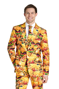 A man is standing against a plain white background, smiling while wearing the Snack Master - Carnival suit by Suitmeister, which is adorned with a vibrant print of hot dogs, french fries, hamburgers, and tacos.