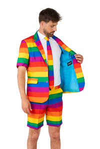 A person is dressed in a Suitmeister Rainbow suit, featuring shorts and a matching tie, revealing the light blue lining inside the jacket.