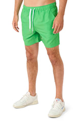 A person is dressed in the TMNT outfit by Suitmeister, featuring vibrant green drawstring shorts, paired with white sneakers. Their legs are visible against a plain white backdrop.