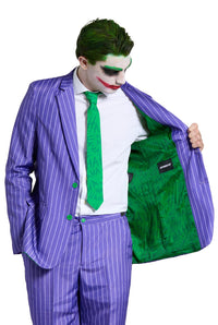 Dressed in The Joker costume by Suitmeister, a person with white face paint and vivid green hair strikes a pose. They sport a purple pinstripe suit complemented by a green tie, holding open the jacket to showcase its green interior adorned with an intricate pattern.