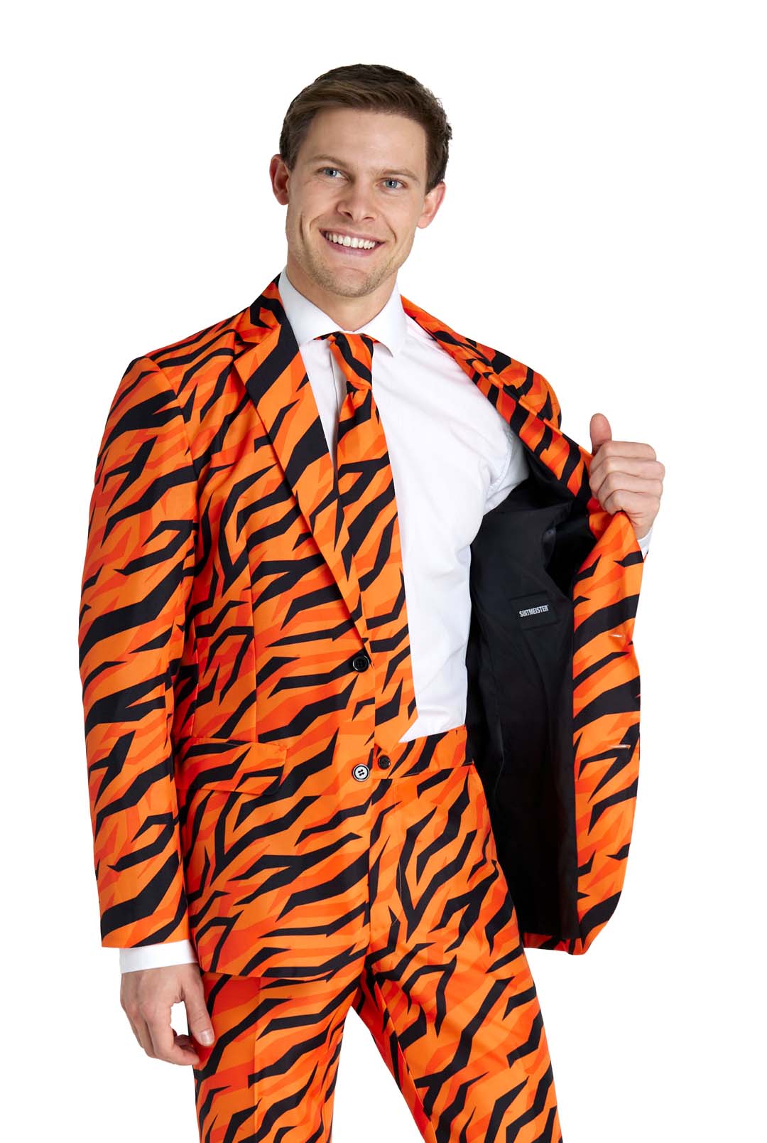 A person is wearing a Suitmeister Tiger suit in vibrant orange, featuring bold black tiger stripes. They complement it with a white shirt and matching tie, smiling as they hold open one side of the jacket to reveal the inner lining.