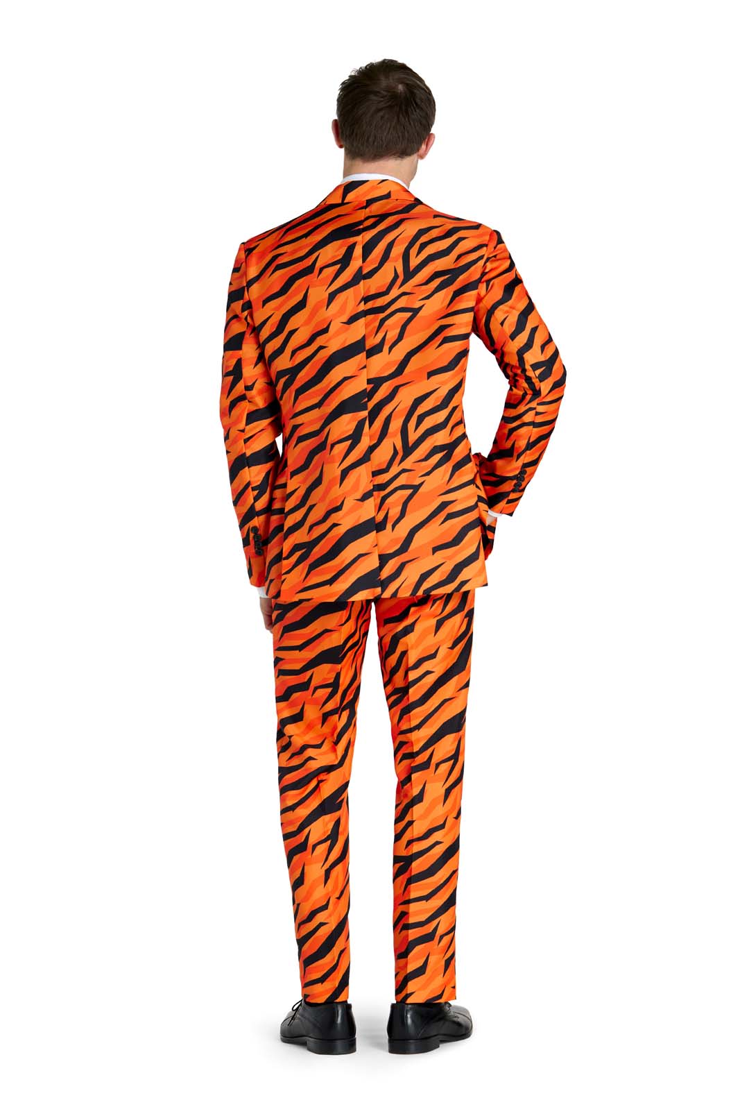 A man is standing with his back to the camera, wearing the Suitmeister Tiger suit Orange with black tiger stripes. Black shoes complete the outfit against a plain white background.