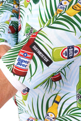 A close-up of an individual donning a vibrant shirt adorned with playful cartoon beer bottle designs. The shirt showcases labels such as "Super Beer" and "Suitmeister," set against a lush, leafy backdrop. The person's hand is partially visible.