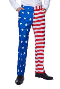 A person is dressed in the Suitmeister USA Flag suit, featuring pants with one leg in blue adorned with white stars and the other in red and white stripes, reminiscent of the American flag. They complement this attire with a white shirt and black shoes.