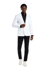 A man wearing a Suitmeister Sequins Blazer White over a black shirt, black pants, and white sneakers is walking confidently toward the camera against a plain white background.